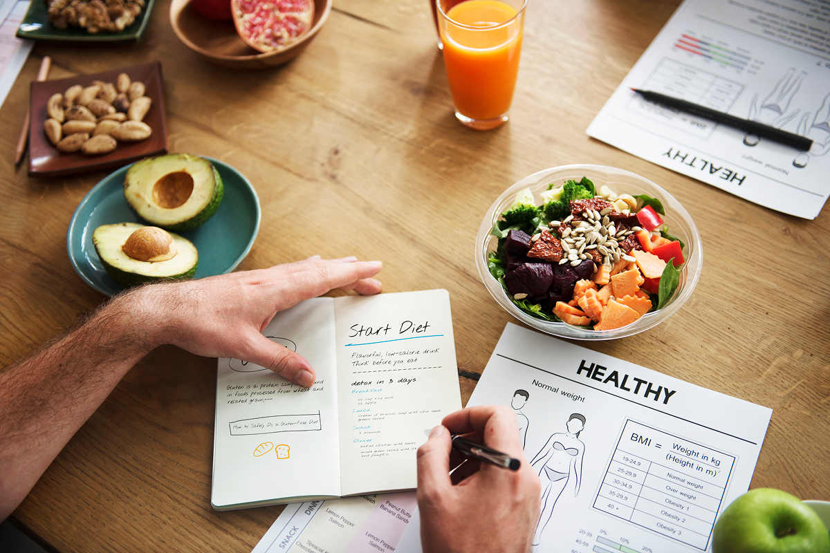 Person planning diet with healthy foods.