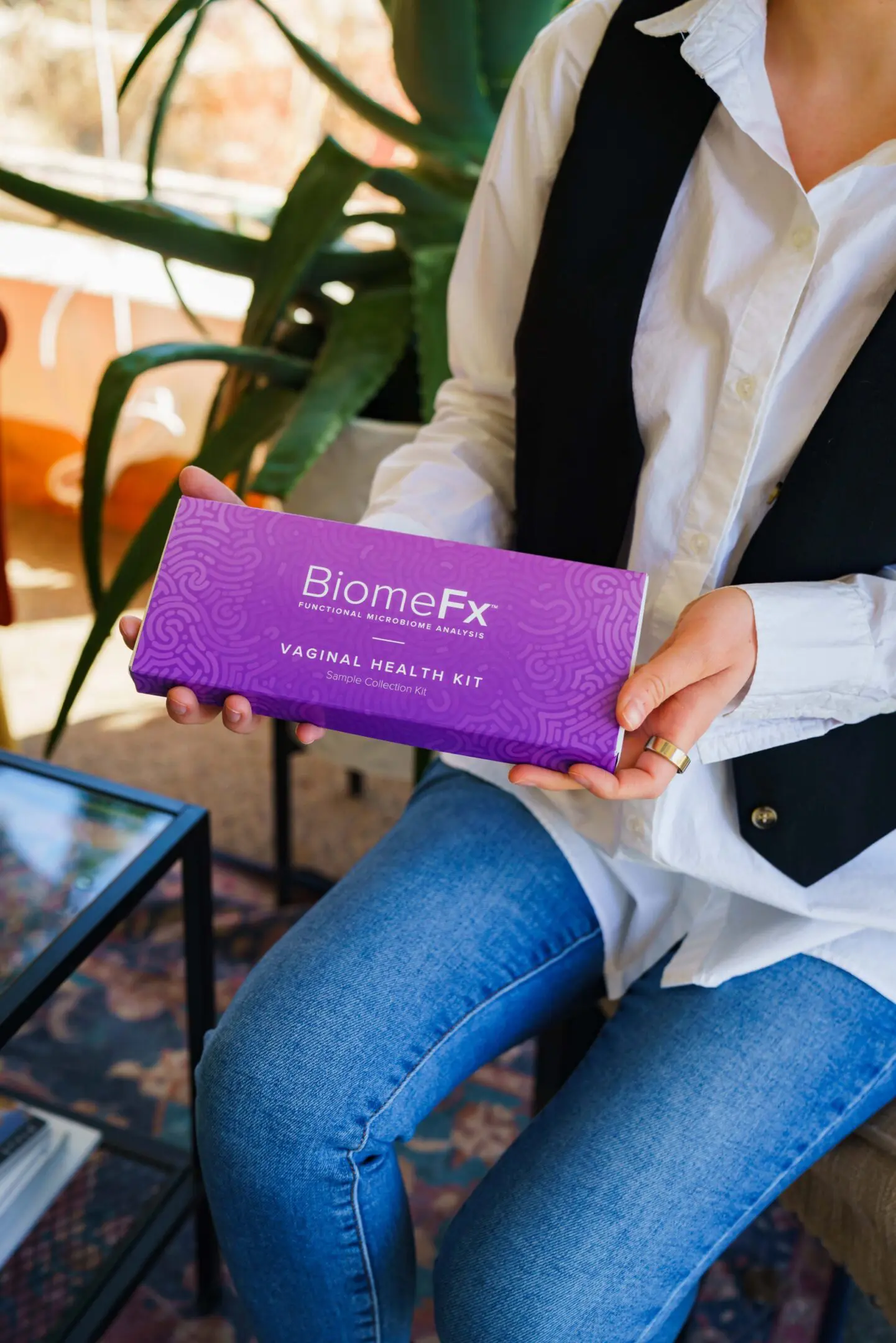 Person holding a purple BiomeFx box with green plants in the background.