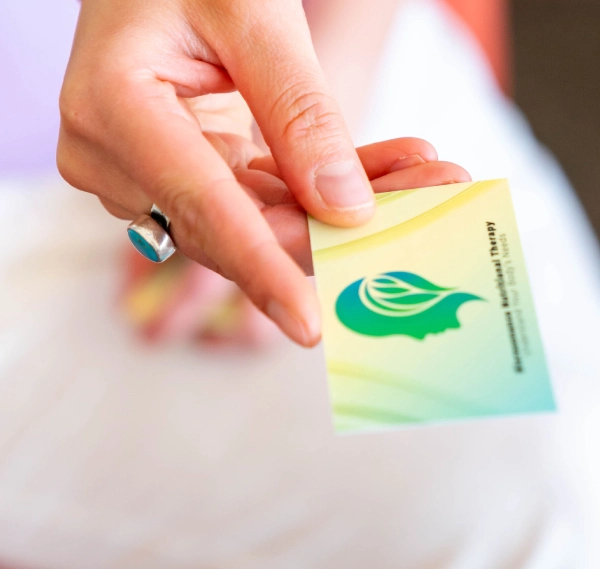 Hand holding a green-themed card with a leaf logo.