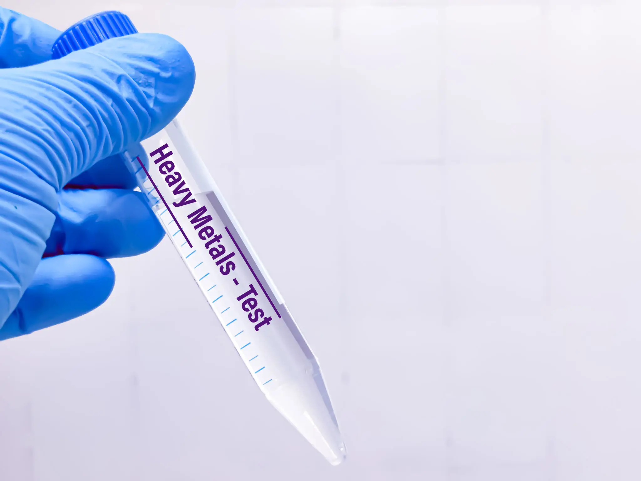 Gloved hand holding a heavy metals test tube.