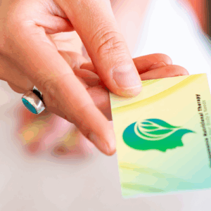Hand holding a green card with a leaf logo.